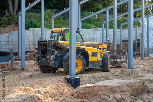 Telescopic handler at a construction site. Construction equipment for loading. Front-end loader for lifting loads, a forklift at a construction site, construction work.
