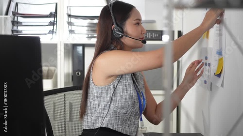 Young asian secretary preparing for online meeting, put the information on the wall in office