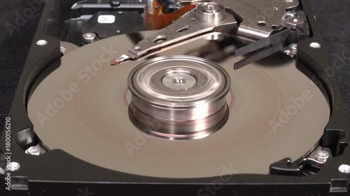 Open hard drive, close-up view, stop spin, word HACKED UN-written