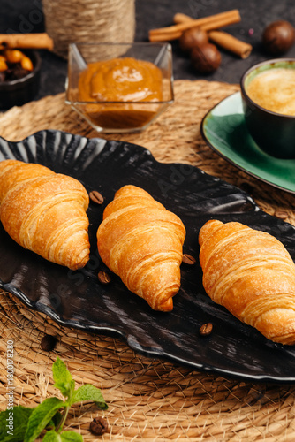An airy golden croissant on a dark background for breakfast whets the appetite