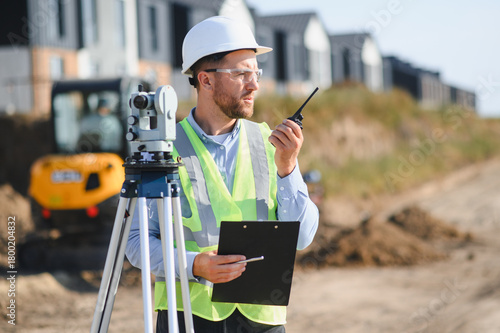 Obraz na plátne Construction engineer communicating on walkie talkie at building site