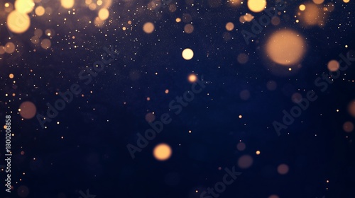 Golden bokeh and glitter on a dark blue background. Abstract festive backdrop for christmas and new year celebrations. Magical sparkling dust particles