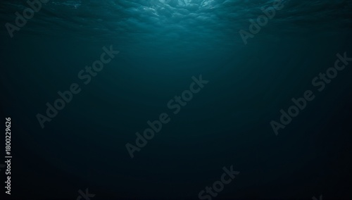 A view from underwater showing sunlight filtering through the surface of the deep blue ocean water