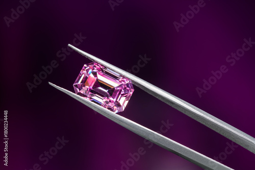 A pink diamond is displayed in a jeweler's setting
