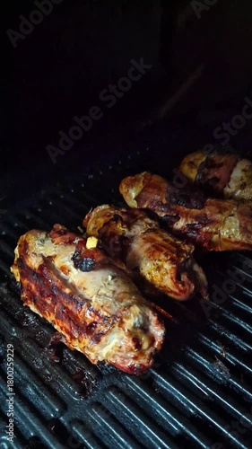 Meat wrapped in bacon being grilled over hot charcoal coals (barbecue cooking)