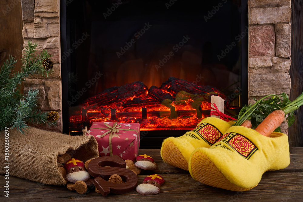 Obraz premium Saint Nicholas - Sinterklaas shoe with carrot and sweets near the fireplace
