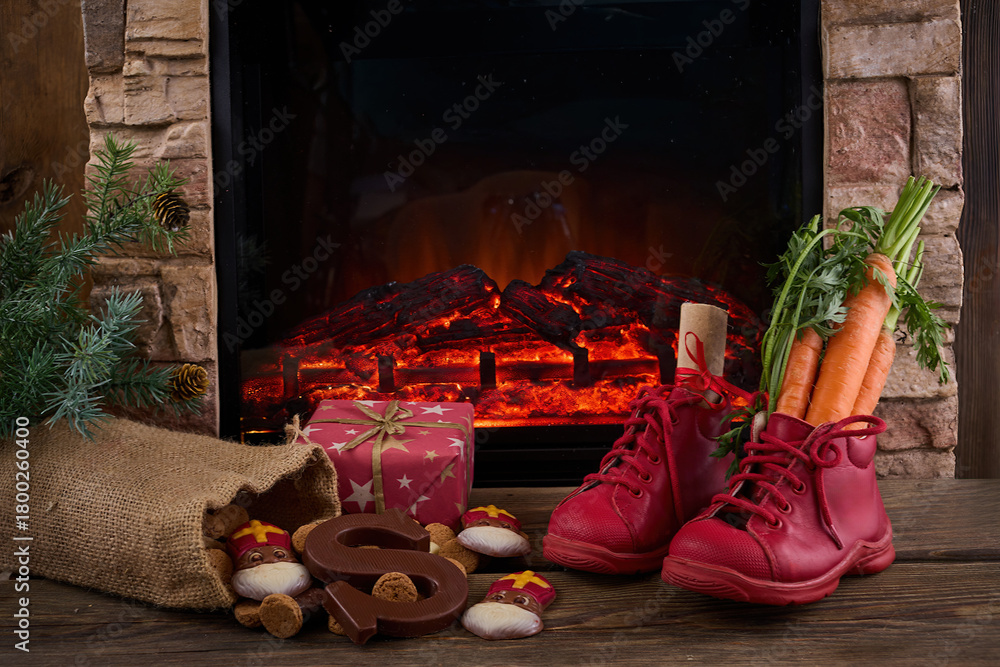 Obraz premium Saint Nicholas - Sinterklaas shoe with carrot and sweets near the fireplace