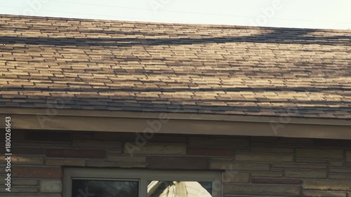 A residential roof displaying wear and aging shingles prior to renovation, with visible surface damage and weathering.