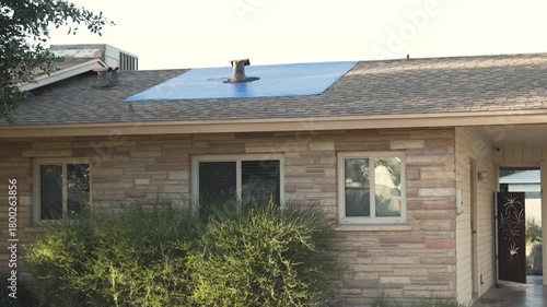 A house roof is leaking and a tarp is installed as a temporary cover.