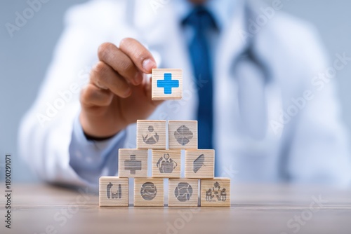 Doctor Placing Medical Cross Block on Wooden Pyramid