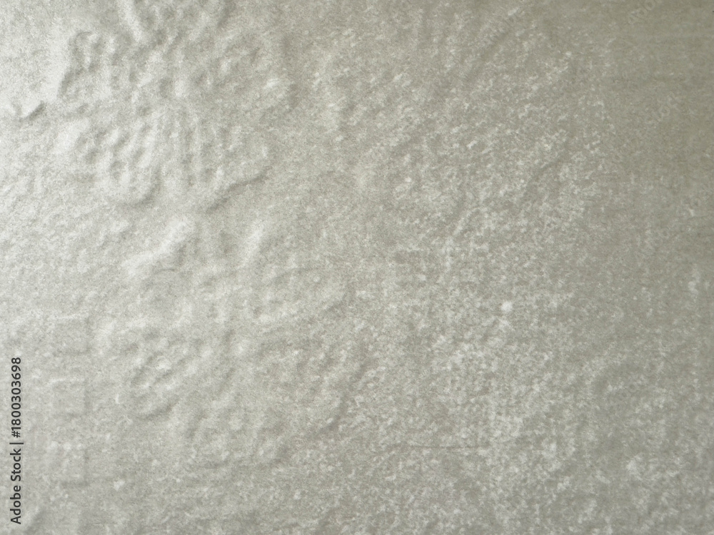 Obraz premium Textured snowflake pattern on light gray surface with subtle shadows