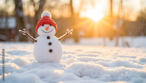 Snowman with red hat smiling in snowy landscape at sunset  