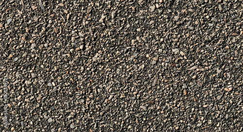 A close-up view of a dark, rough, granular surface, possibly asphalt or gravel, showing its detailed texture and composition.