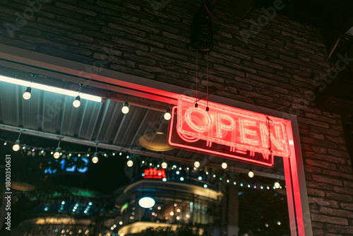 OPEN red neon light poster on the corner of a window in a night urban scene
