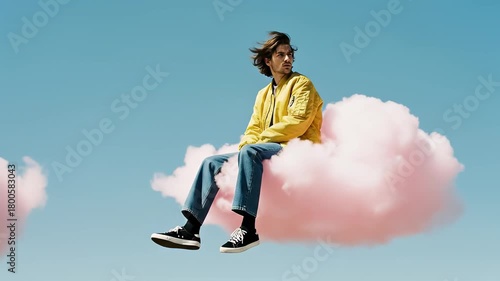 A young man floating on a pink cloud in the blue sky. Surreal dream and imagination concept. Minimalist fantasy animation with copy space