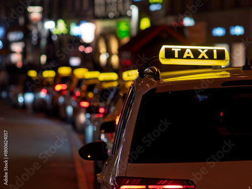 Illuminated Taxi Signs Lining a City Street at Night in Munich Germany