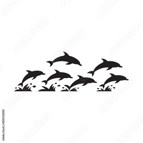 Silhouette of a pod of dolphins leaping from the ocean waves