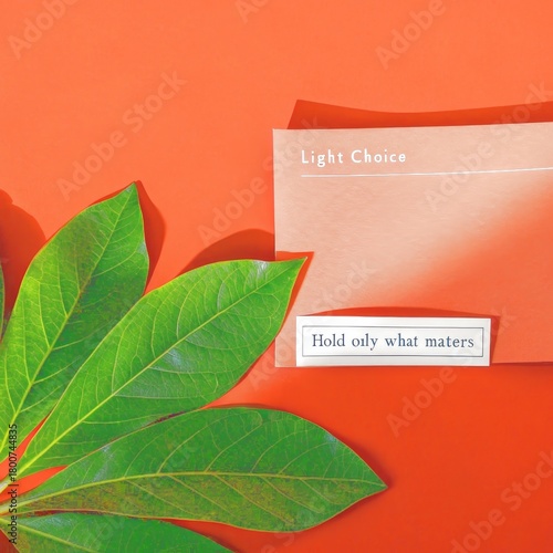 Orange surface with green leaves, peach card, and text label