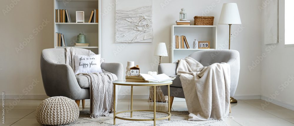 © Pixel-Shot - Interior of light living room with cozy armchairs and books on coffee table
