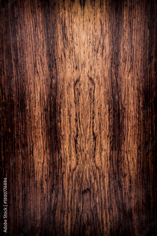 Naklejka premium background is made of old wood. an old board. the texture of a rustic table. Cocobolo, Dalbergia, red wood, a place for a text or object, frame, vignetting. the effect of aging, vertical