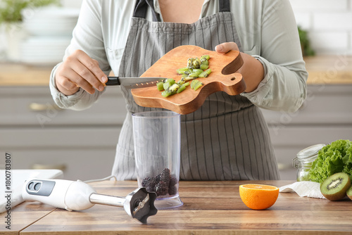 Young woman pouring chopped...