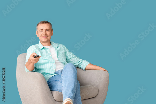 Old man with TV remote sitt...
