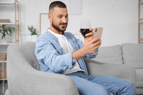 Young man with glass of win...