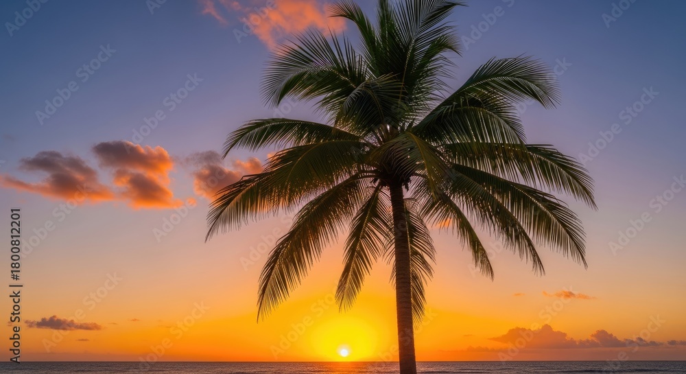 Obraz premium A vibrant sunset over the ocean with a lone palm tree silhouetted against the sky.
