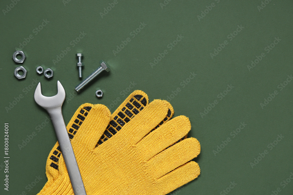 Naklejka premium Tap bolts, gloves and wrench on green background