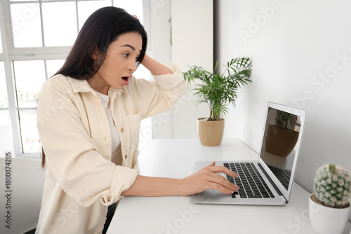Shocked young woman using l...
