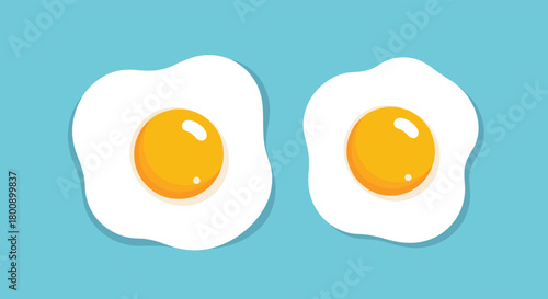 A pair of freshly prepared sunny-side-up fried eggs, featuring bright yellow yolks and fluffy white albumen, presented on a clean, light blue surface.