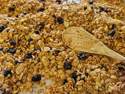 Closeup of the texture of golden freshly baked homemade, healthy, granola with dried cranberries.