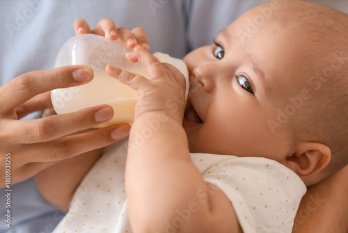 Mother feeding baby with mi...