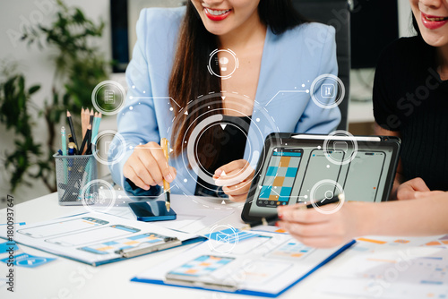 UX UI designers reviewing mobile app interface elements on a digital tablet, showcasing teamwork, creative planning, and modern app design