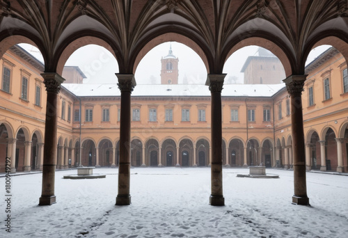 Courtyard of a historic university in Bologna, its porticoes lined with snow