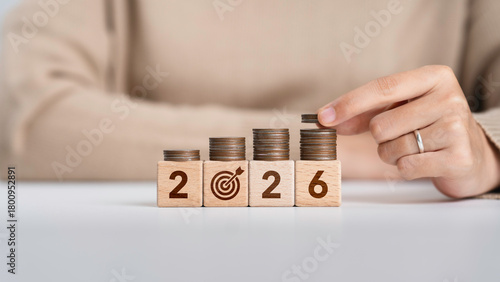 Wallpaper Mural Financial planning concept for 2026 with Hand place coins stacked coins on wooden number blocks for saving goals, investment growth, wealth strategies for 2026 year. Budget and tax. Torontodigital.ca