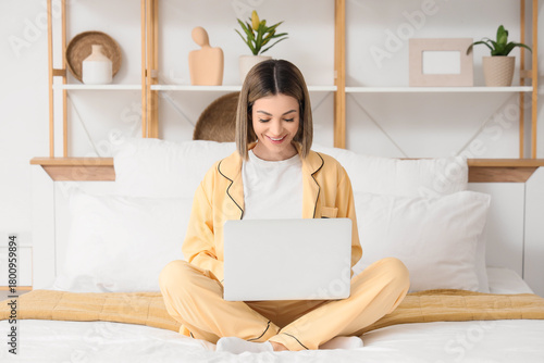 Young woman using laptop to...