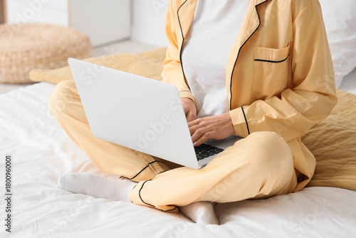 Young woman using laptop to...