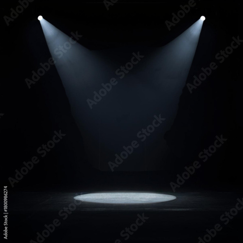 Two spotlights illuminating a dark stage with a spotlight on the floor silhouette