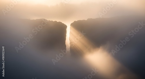 Sun rays breaking through the clouds over a mountain landscape creating a dramatic and serene atmosphere during sunrise or sunset