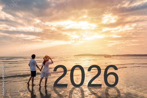 Young woman traveler holding man's hand and looking at beautiful sunset on the tranquil beach celebrating New Year 2024, couple on vacation in summer concept