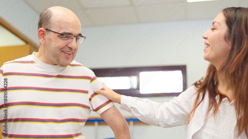 Obraz premium Caregiver supporting man with physical disability during therapy