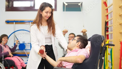 Physiotherapist assisting man with physical disability with rehabilitation exercise