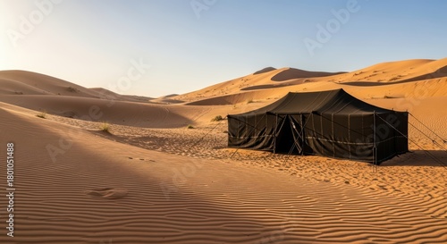 Desert tent in vast sand dunes at sunset
