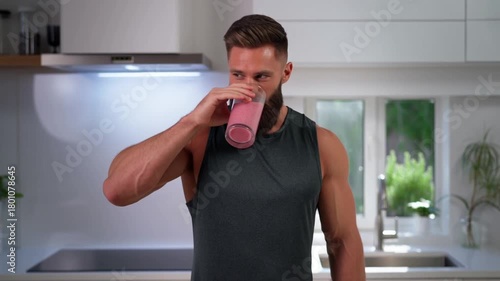 A strong man enjoying a delicious smoothie in a modern kitchen, focusing on wellness Stock Video