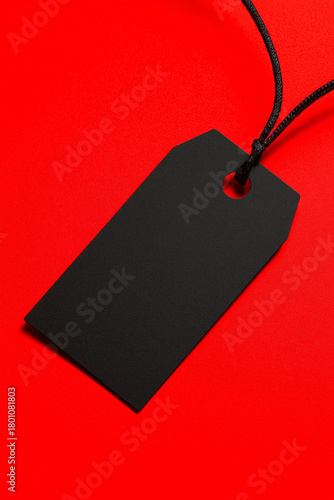 Black Blank Tag Hanging on Red Background for Branding or Sale Concept