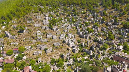 Kayakoy, Turkey. Drone view of ancient stone ruins in abandoned ghost town on mountain hill under bright sunlight.. Aerial View