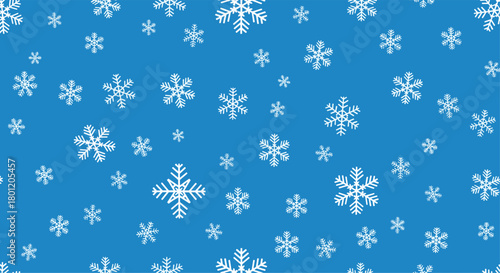 Festive seamless pattern with white snowflakes falling randomly on a vibrant blue background ideal for winter and Christmas designs.