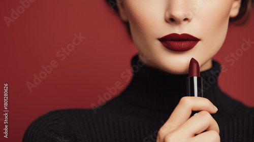 Lipstick woman holding dark red lipstick near lips with elegant makeup look and stylish beauty detail