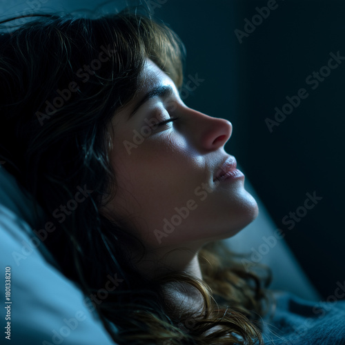 Beautiful woman enjoying restful deep sleep in a dark calm bedroom